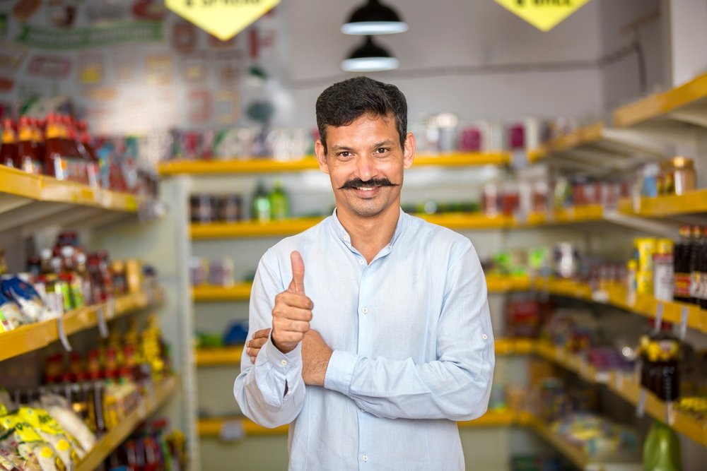 Happy,young,man,show,thumbs,up,at,grocery,store,products.